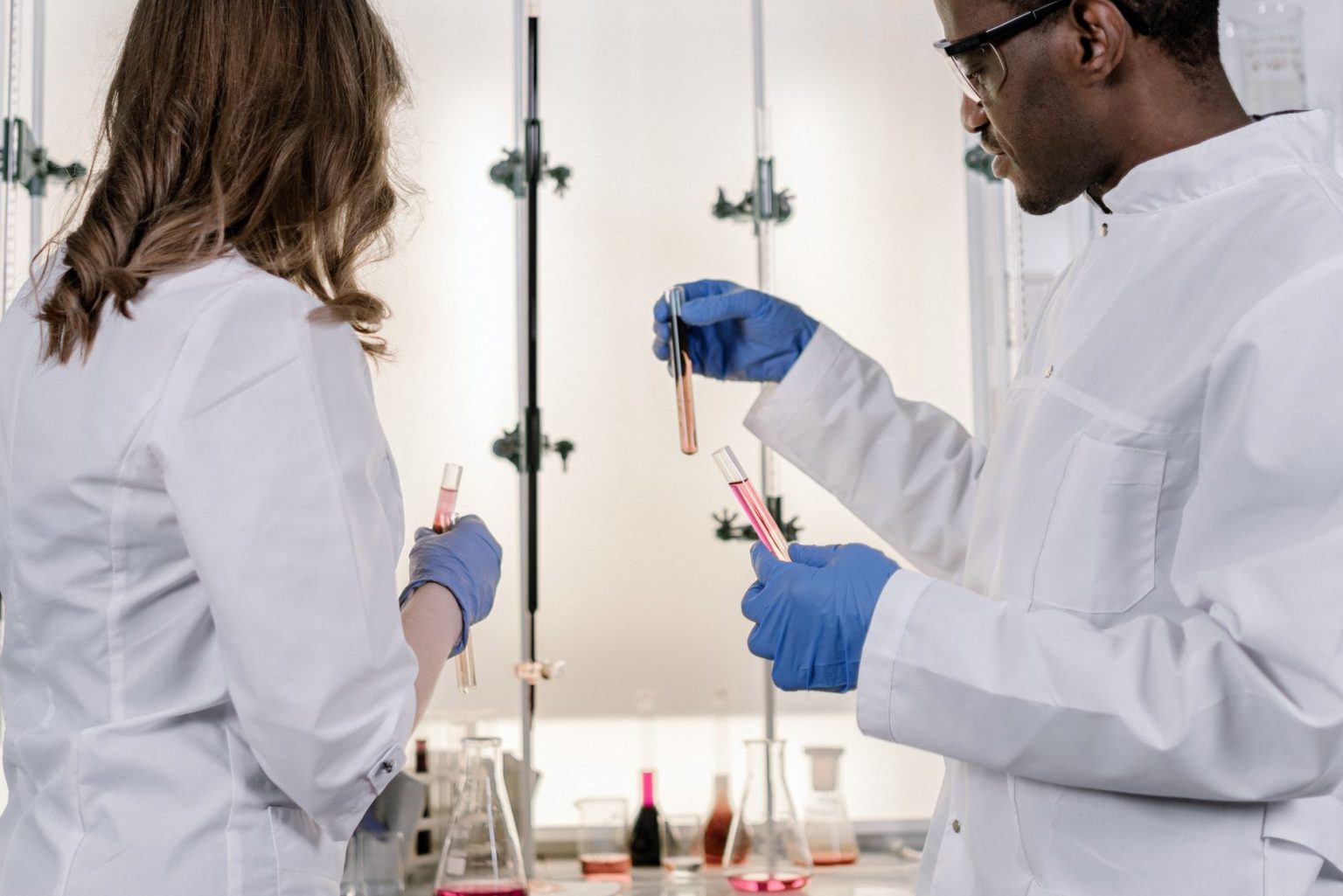 Dois cientistas trabalham juntos com tubos de ensaio em um laboratório moderno.